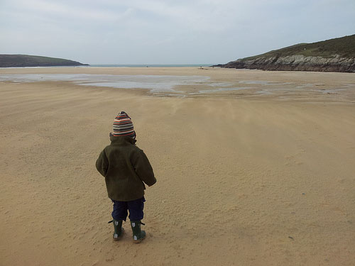 Child looking out to see on Cornish beach